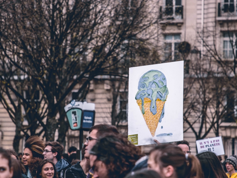 Personas jóvenes manifestándose por el cambio climático. Cargan pancartas y carteles. Foto: Unsplash.